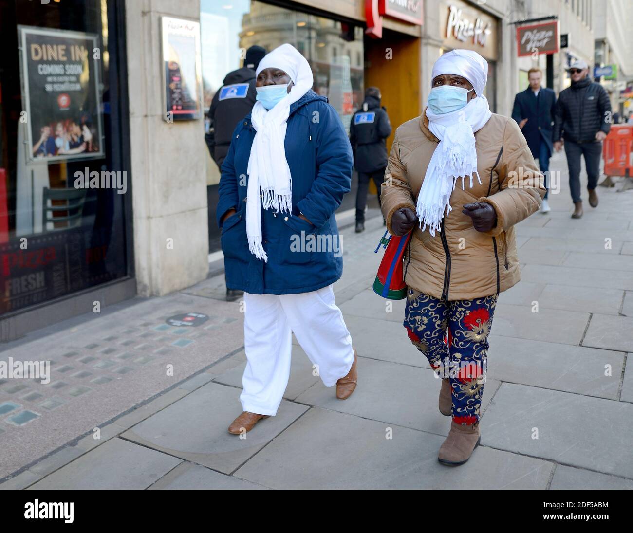 Londra, Inghilterra, Regno Unito. Persone che indossano maschere facciali durante la pandemia COVID, 2020 Foto Stock