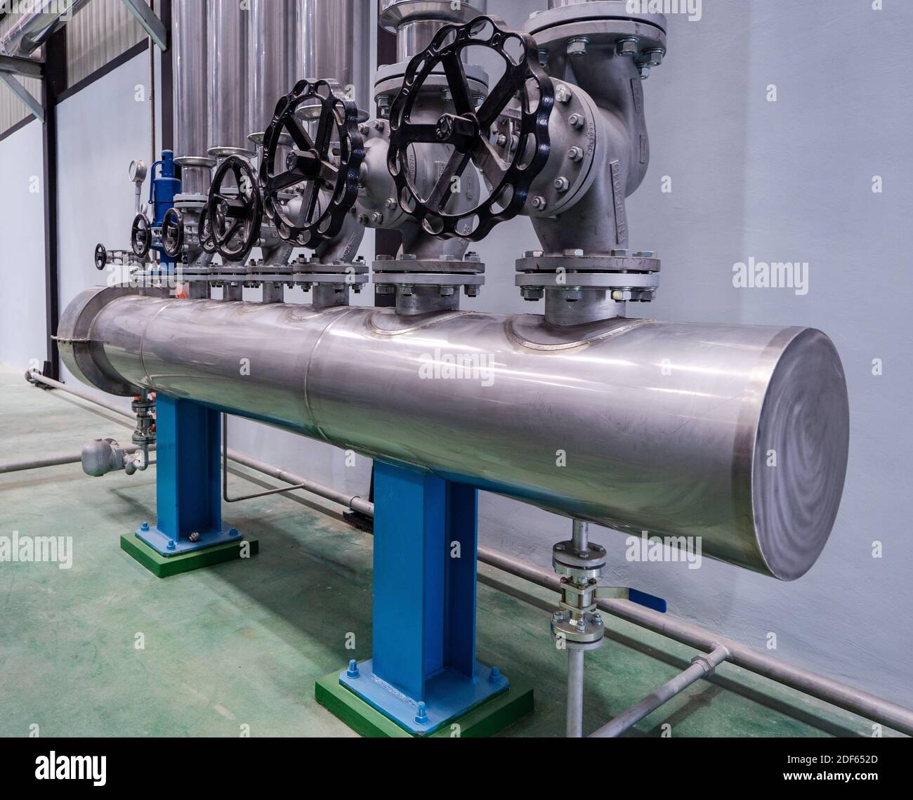 Collettore a vapore presso l'impianto di lavorazione industriale, utilizzato per distribuire il vapore sotto pressione a diversi macchinari. Foto Stock