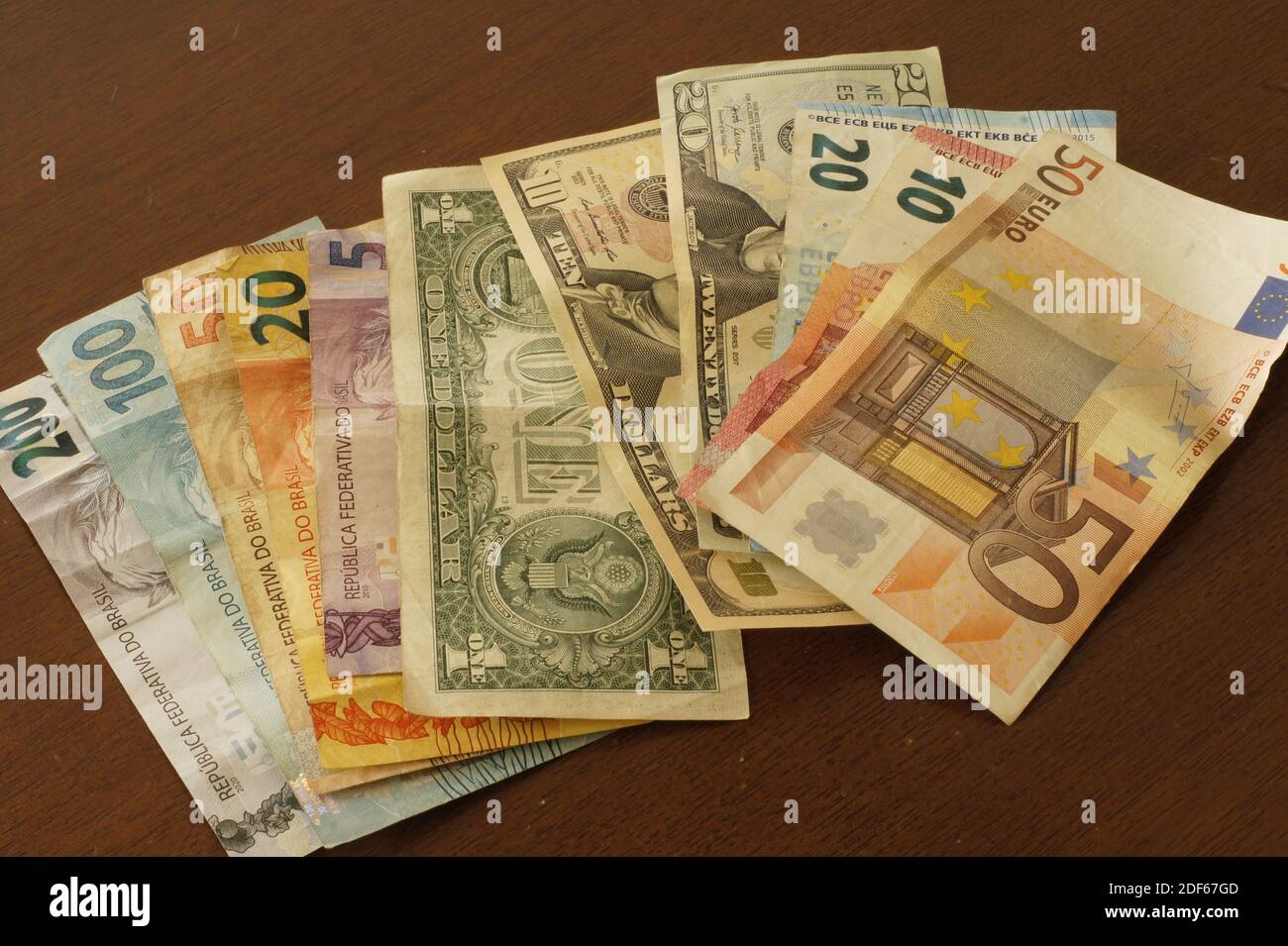 Banconote in reais brasiliano, euro e dollari su un tavolo. Foto Stock