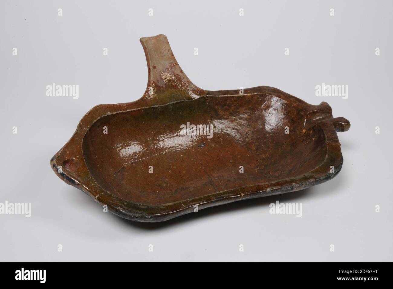 Raccogli grasso, Anonimo, ca. 1500, smalto al piombo, terracotta, Generale: 13 x 41.5 x 28cm (130 x 415 x 280 mm), vassoio di grasso di terracotta rossa con smalto al piombo verde e marrone. Il raccogli-grasso ha due gambe, con un motivo floreale schiacciato intorno alle gambe, uno stelo, un canale di versamento e un piccolo orecchio piatto. Circa un quarto della trappola di grasso consiste di un supplemento moderno, 1972 Foto Stock