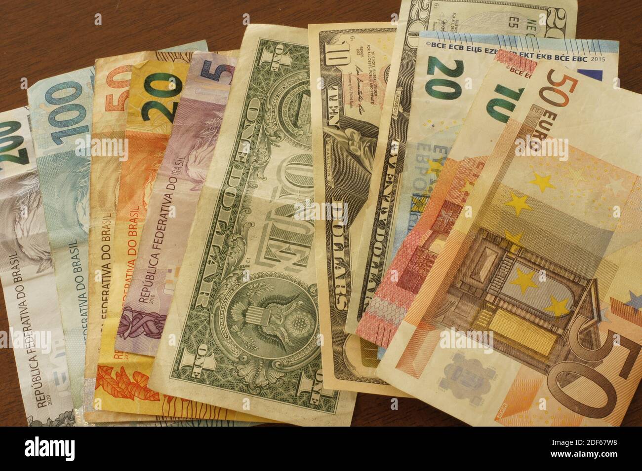 Banconote in reais brasiliano, euro e dollari su un tavolo. Foto Stock