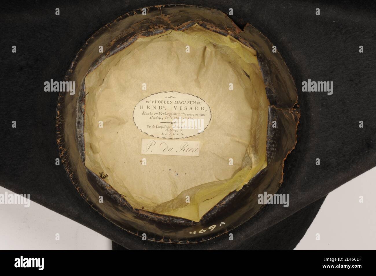Cuciture, Hendk Visser, 1830, pelle, seta, feltro, carta, cucita, Generale: 16 x 44 x 55,5 cm (160 x 440 x 555 mm), Stitch indossato dal Comandante dei Guardiani nel 1830. Il punto contiene tre lati ed è fatto di feltro duro nero. Nella parte anteriore sinistra un anello di nastro di seta pende sul bordo. Il tubo interno è realizzato in pelle. La sfera è rivestita di seta molto sottile. Sul fondo si trova un'etichetta di carta IN 't HOEDENMAGAZIJN at HENDK. PESCATORE, produce e vende tutti i tipi di cappelli, grandi e piccoli. Sul Langebrug, all'angolo del Diefsteeg, a LEYDEN. Sotto che è scritto su un'etichetta P. du Rieu Foto Stock