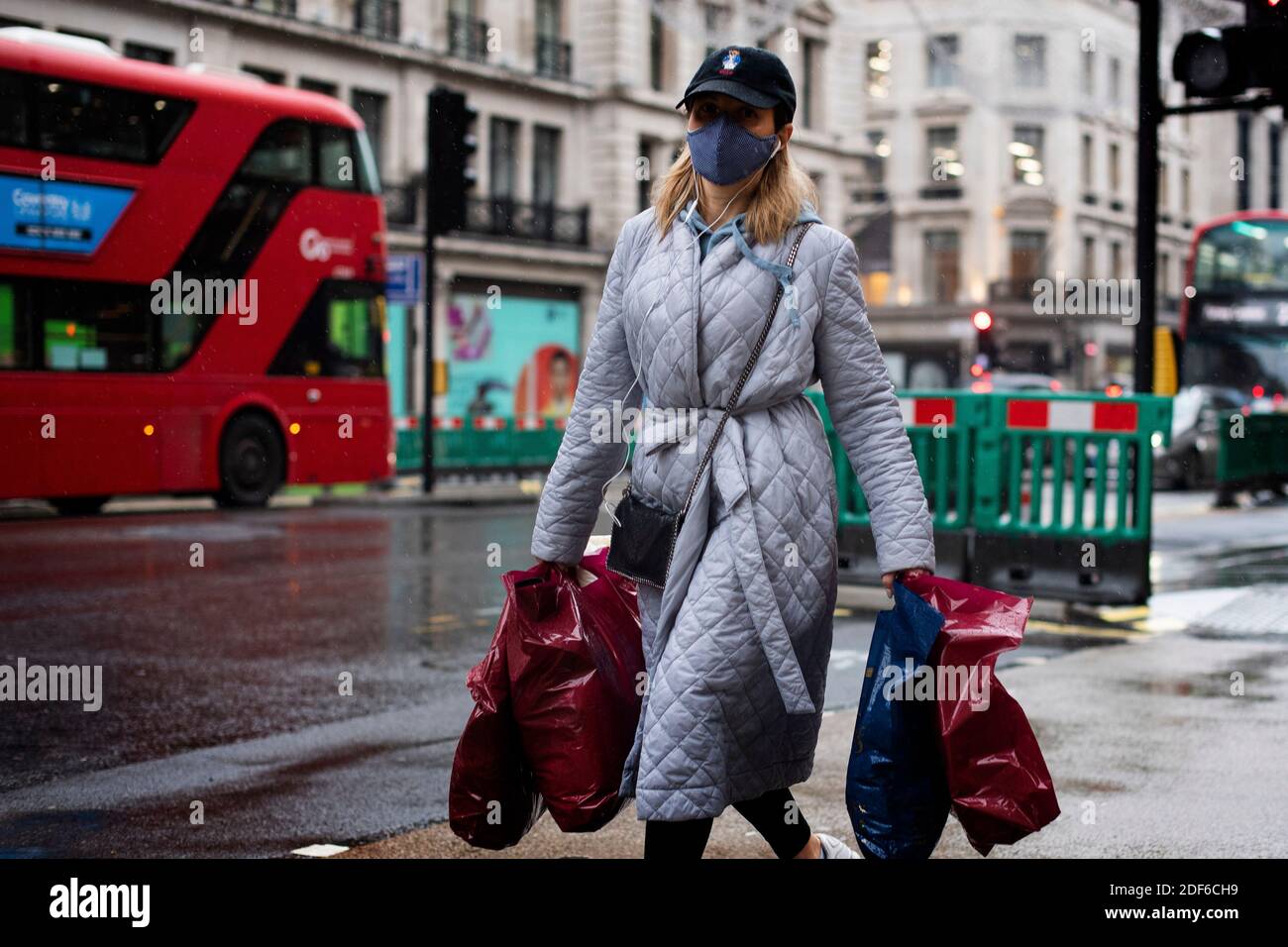Un acquirente indossa una maschera facciale in Regent Street, Londra, dopo la fine del secondo blocco nazionale e l'Inghilterra ha un sistema rafforzato di restrizioni al coronavirus. Foto Stock