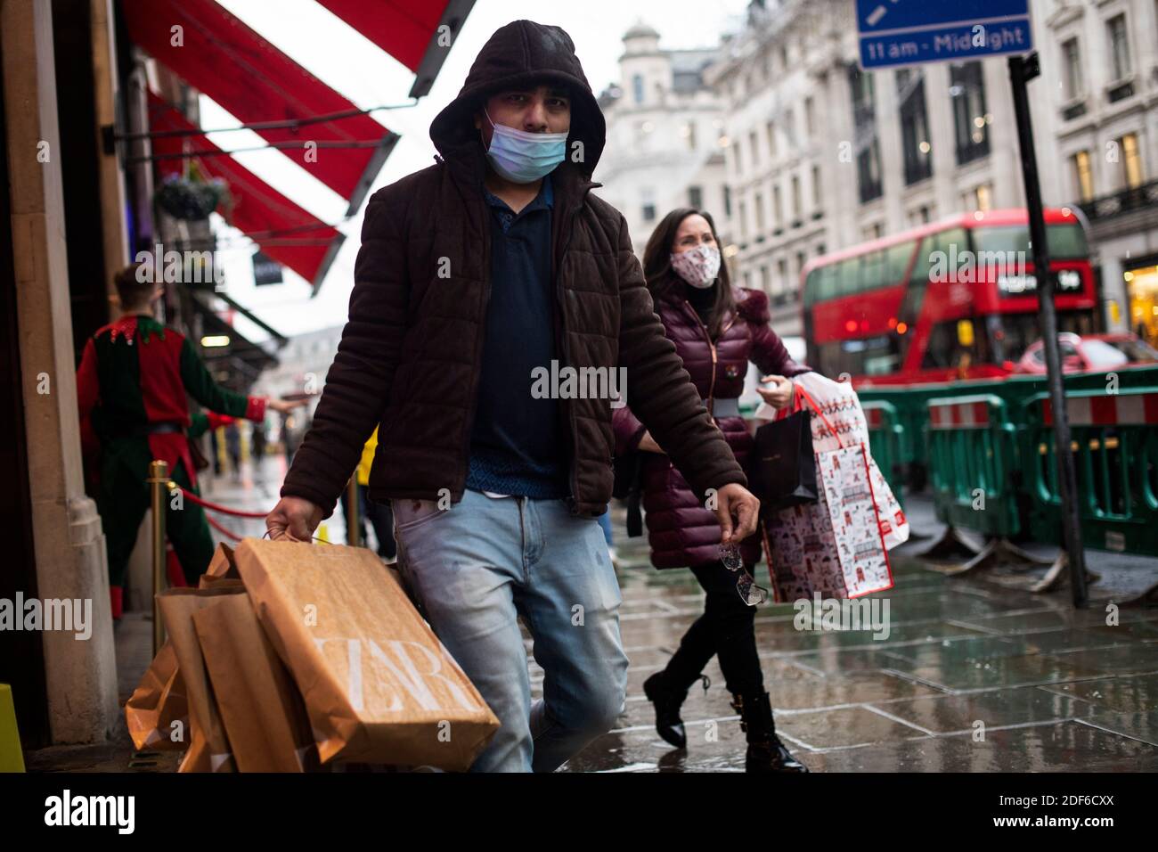 Gli acquirenti indossano maschere a Regent Street, Londra, dopo la fine del secondo blocco nazionale e l'Inghilterra ha un sistema rafforzato di restrizioni del coronavirus. Foto Stock