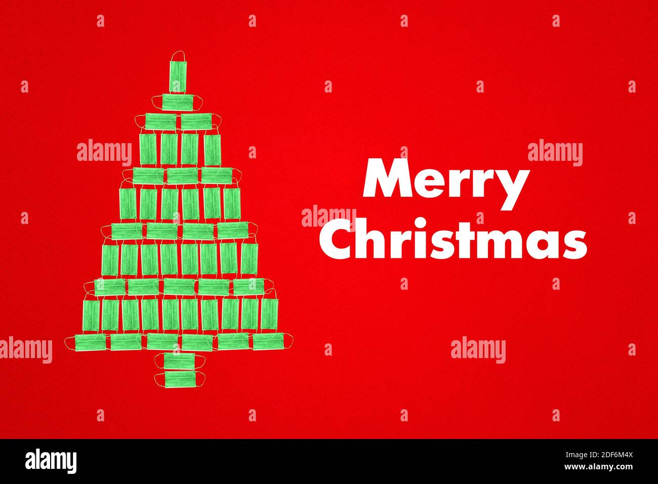Albero di Natale verde fatto di maschere mediche e l'iscrizione Buon Natale. Idea creativa. Concetto di anno nuovo. Foto Stock