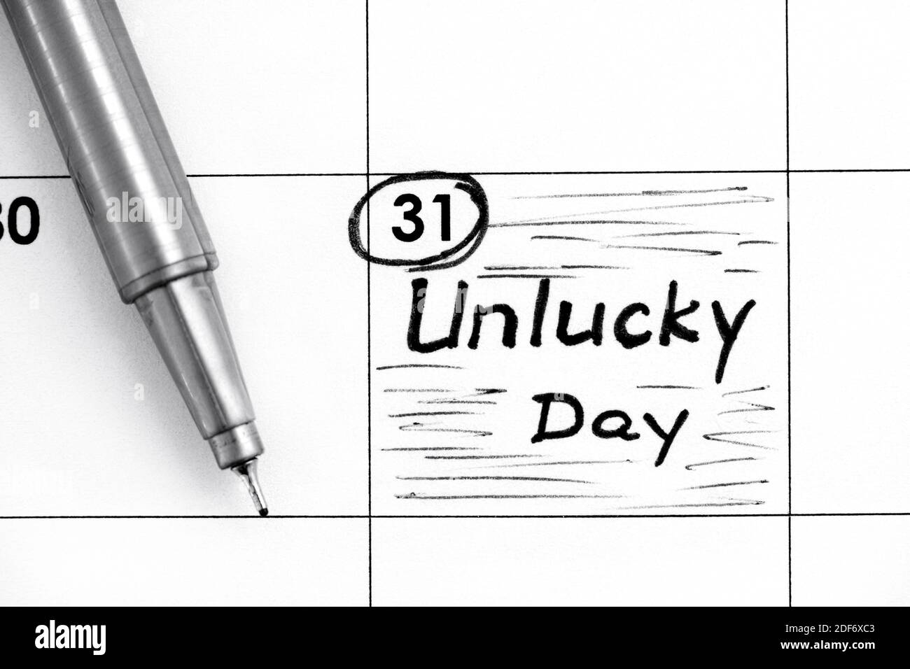 Promemoria giorno sfortunato in calendario con penna. Primo piano Foto Stock