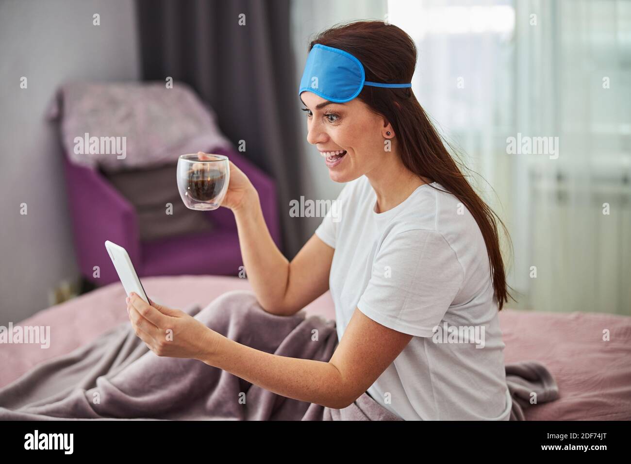 Donna felice che ottiene notizie piacevoli sulla sua cella Foto Stock