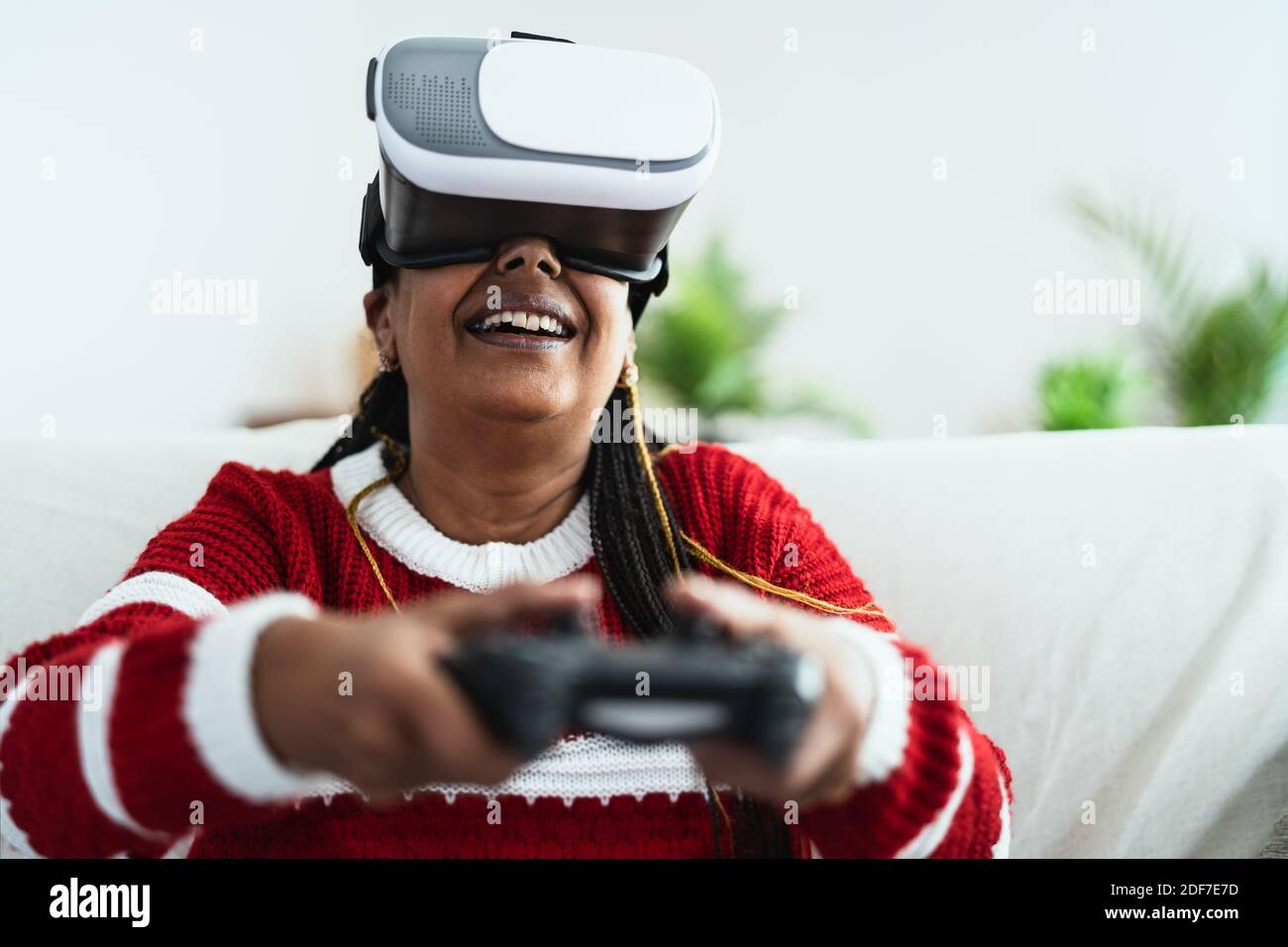 Donna anziana africana che si diverte con la nuova realtà virtuale di gioco esperienza tecnologica Foto Stock