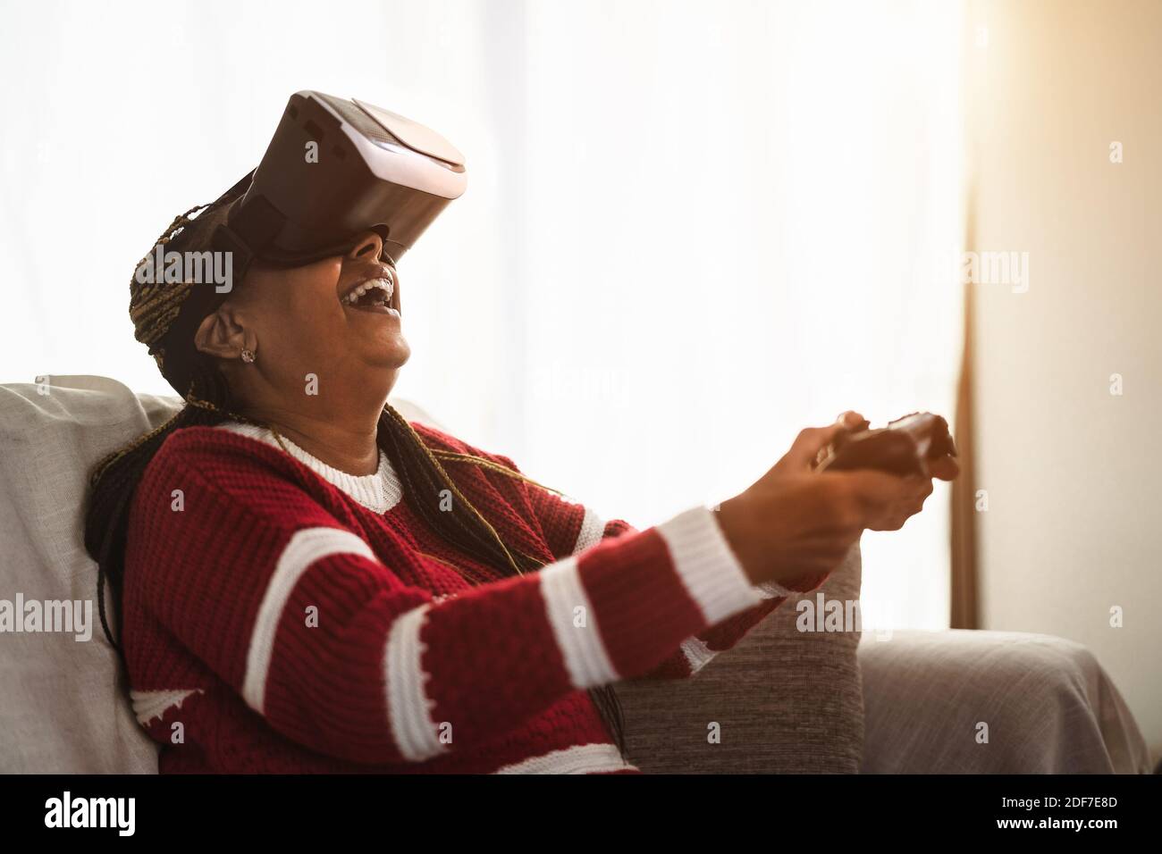 Donna anziana africana che si diverte con la nuova realtà virtuale di gioco esperienza tecnologica Foto Stock