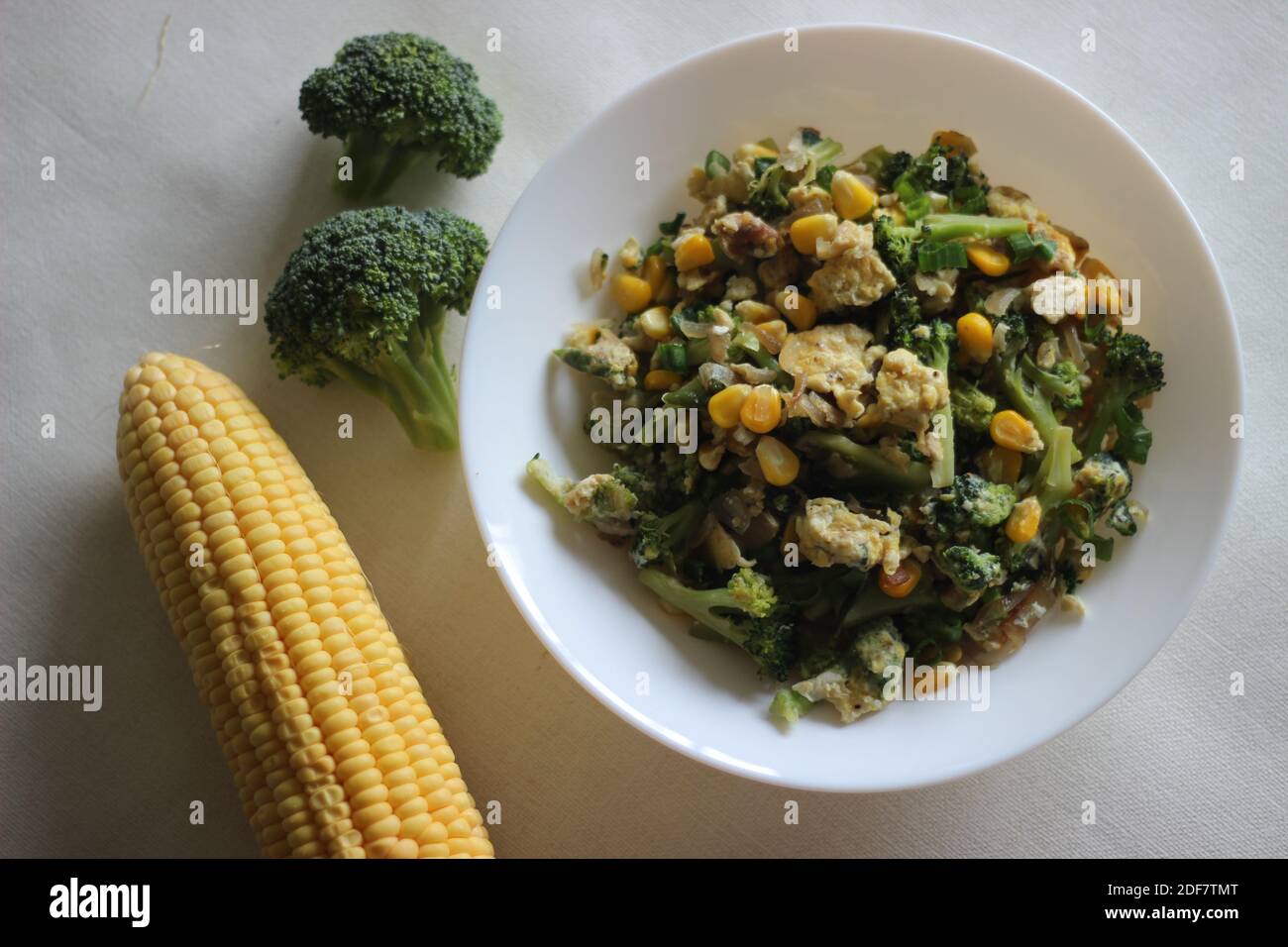 Uova strapazzate con broccoli, mais dolce e cipollotti, una colazione sana Foto Stock