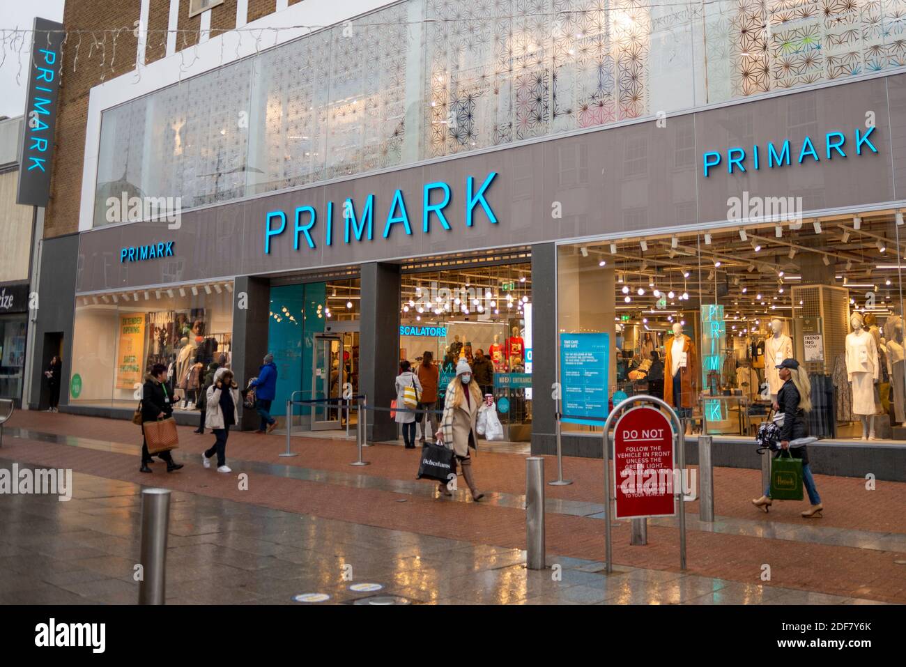 Nuovo negozio Primark in High Street, Southend on Sea, Essex, Regno Unito, con gli acquirenti di passare in cattive condizioni meteorologiche. Sabbia, condizioni di bagnato. Donna con maschera facciale Foto Stock