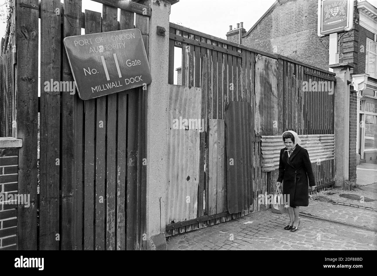 Regno Unito, Londra, Docklands, Isle of Dogs. Inizio 1974. Dorset Arms, (a destra) 377-379 Manchester Road. PLA No. 11 Gate, Millwall Dock. La pista ferroviaria è visibile sulla strada acciottolata. Foto Stock