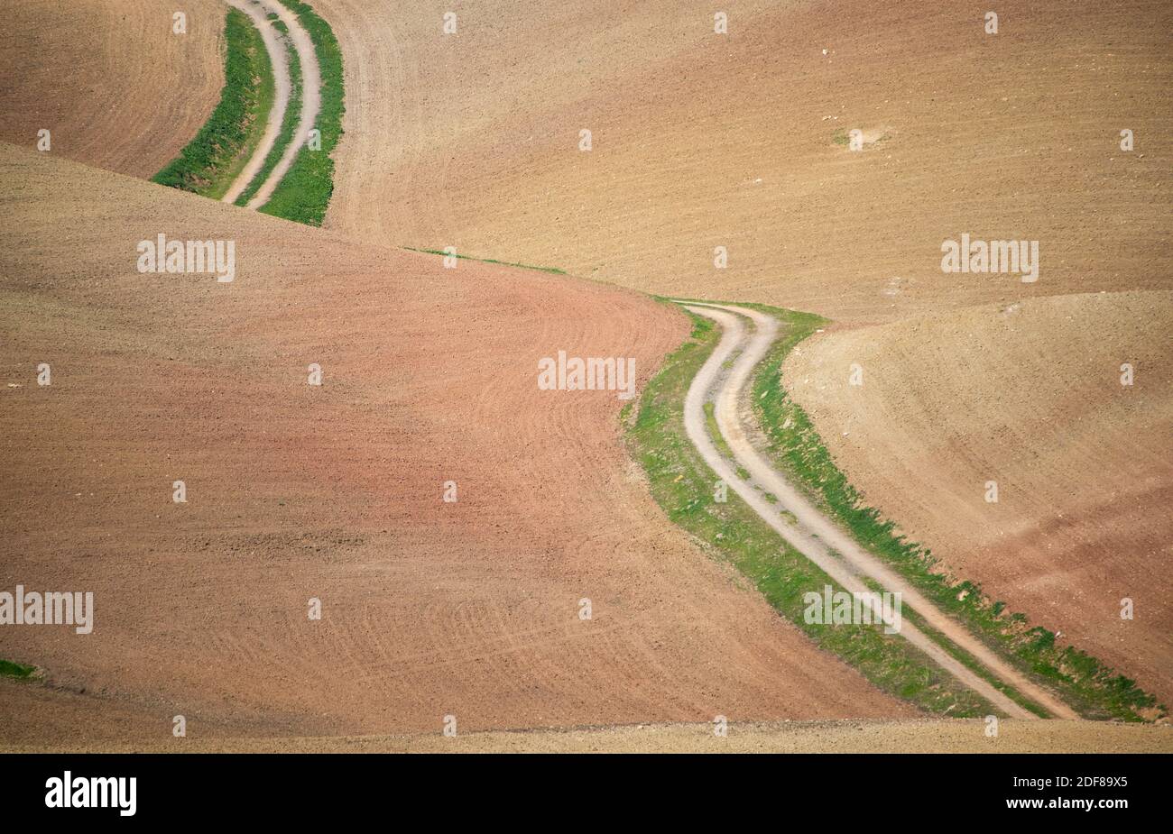 Strada tortuosa attraverso il paesaggio asciutto con campi vuoti in Andalusia, Spagna Foto Stock