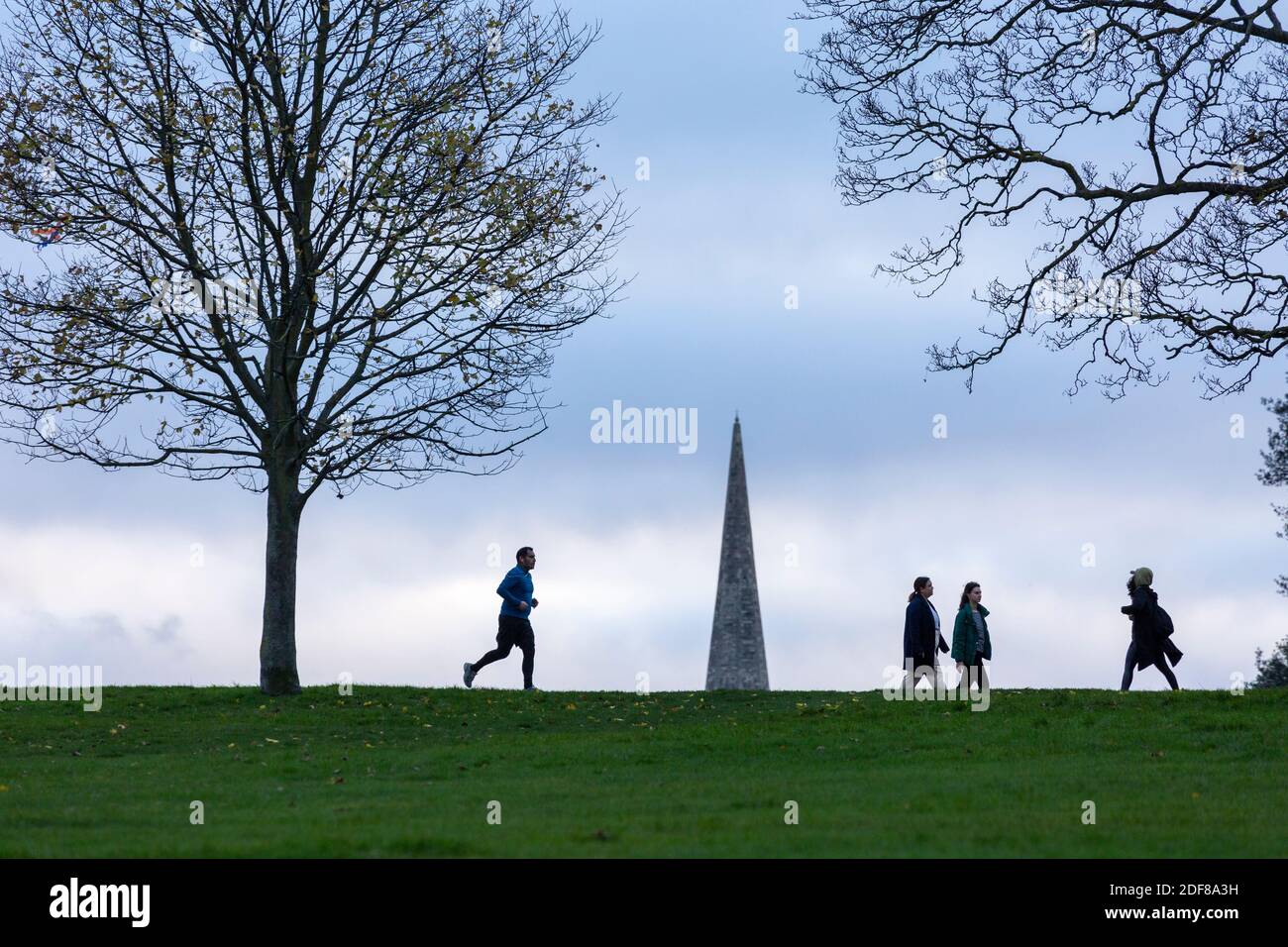 Persone che si esercitano nel Brockwell Park con il campanile della Santa Trinita' Chiesa sullo sfondo, Londra Foto Stock