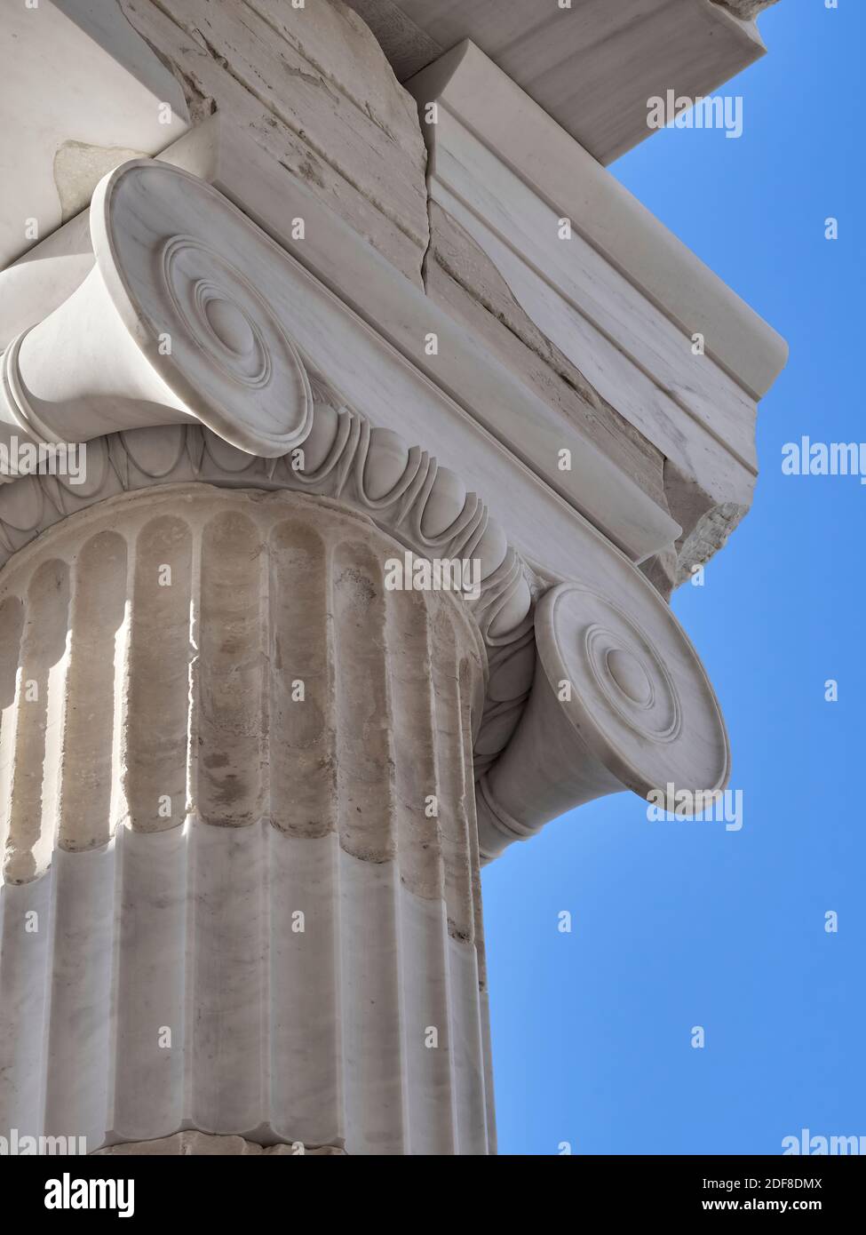 Spirali e linee. La meravigliosa forma dettagliata di questa colonna restaurata in stile ionico del tempio Athena Nike è enfatizzata dal cielo blu. Foto Stock