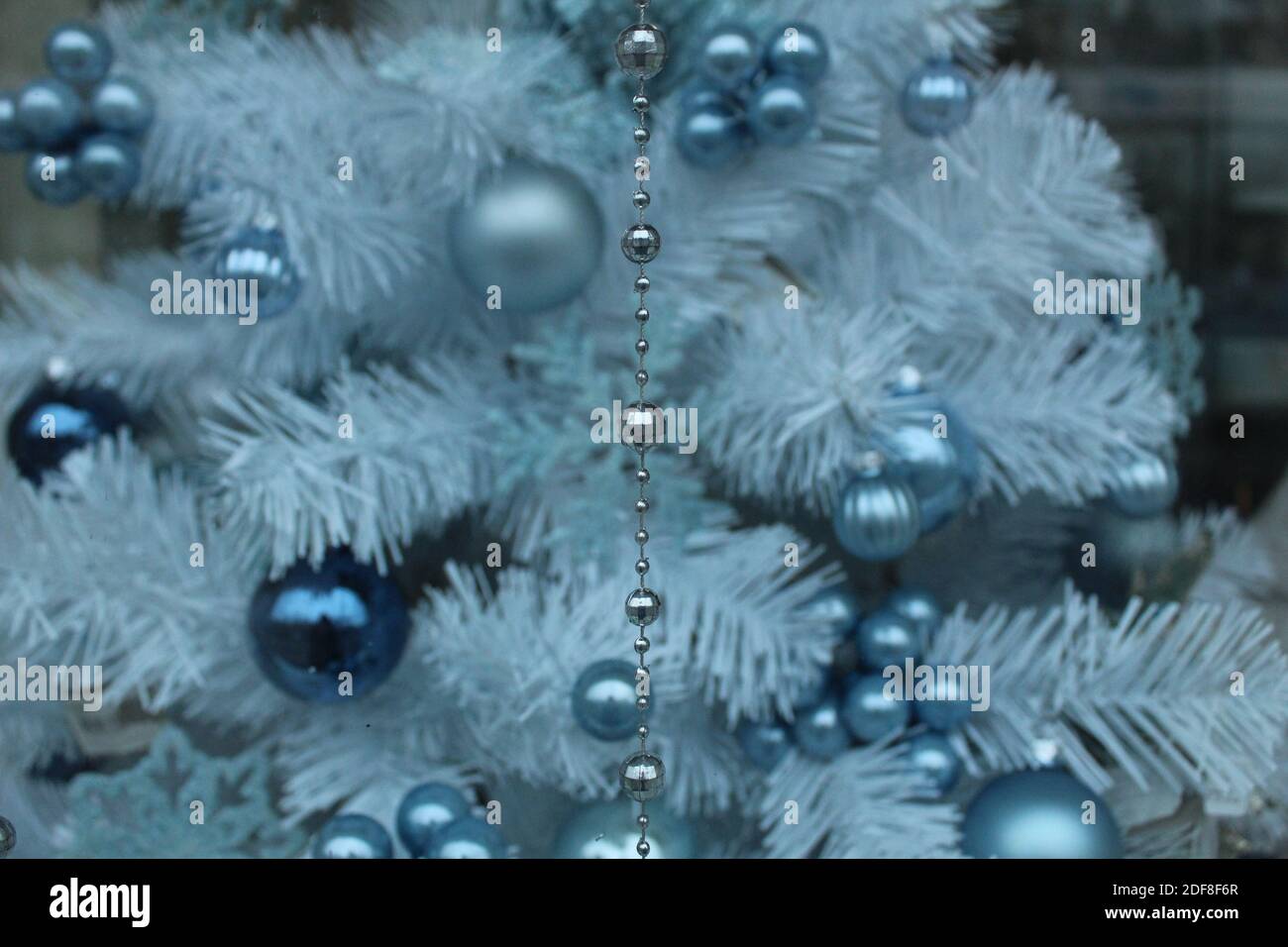 albero di abete bianco argento con giocattoli in argento e blu. Foto Stock