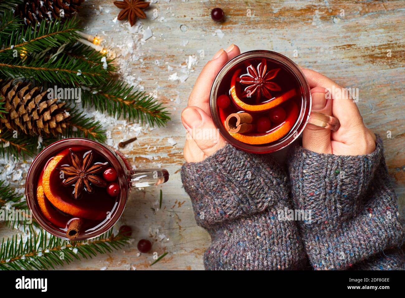 Le mani della donna tengono una tazza di VIN brulé caldo Foto Stock