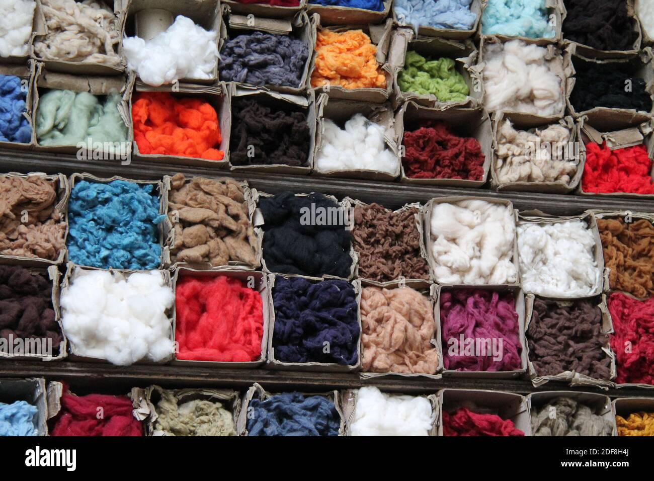 Una collezione mista colorata di fibre di cotone immagazzinate. Foto Stock