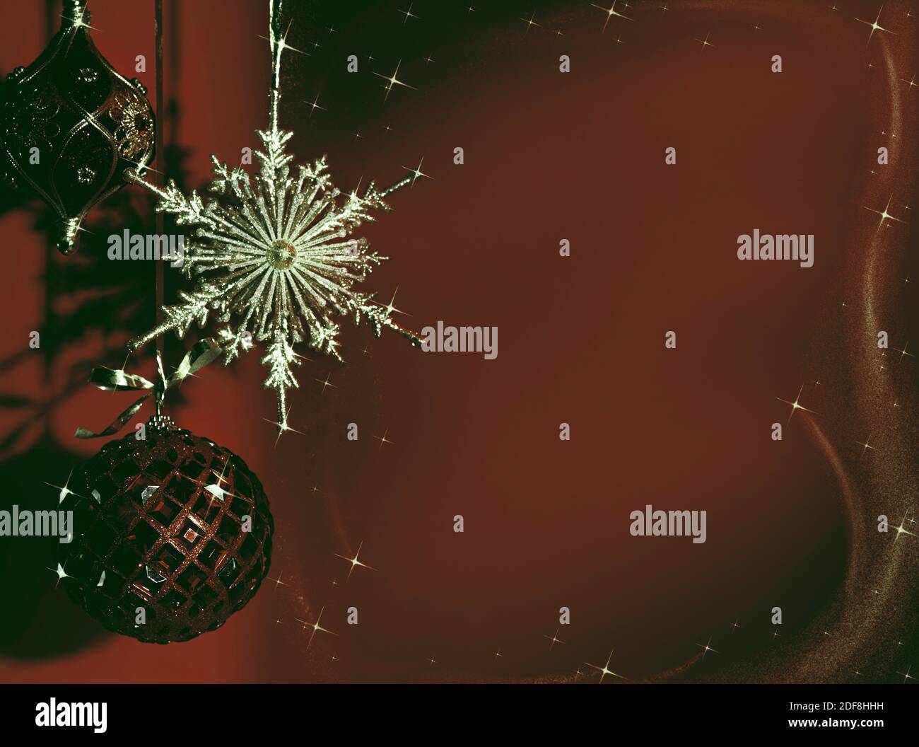 Oro lucido e rosso ornamento di Natale su sfondo rosso scuro in toni drammatici sbiaditi. Vacanze invernali artistiche, concetto di nuovo anno. Foto Stock