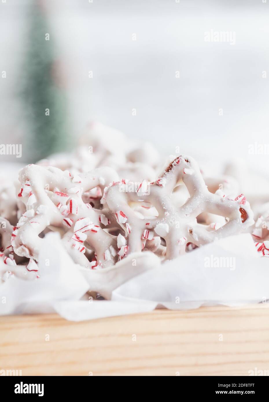 Prettzel ricoperti di cioccolato bianco o yogurt fatti in casa con pezzi di canna caramella schiacciata. Messa a fuoco selettiva con primo piano e sfondo sfocati. Foto Stock