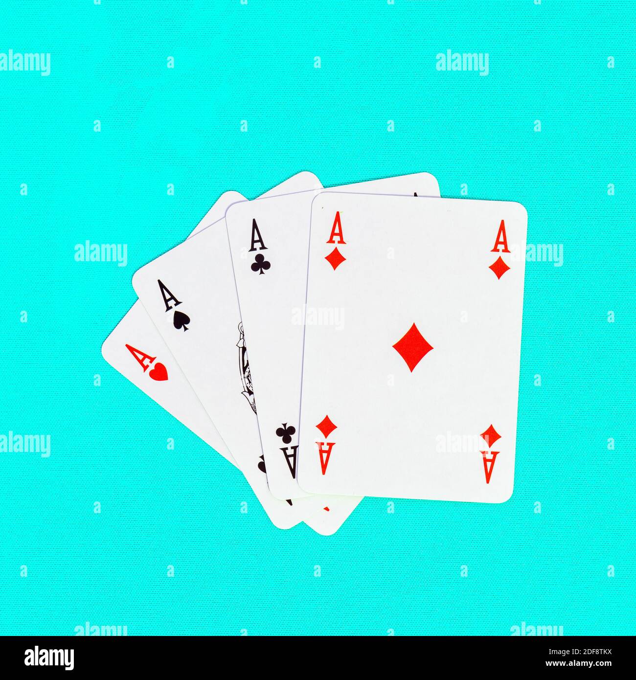 Quattro carte da gioco che raffigurano assi, mazze, picche, diamanti, cuori su uno sfondo colorato Foto Stock