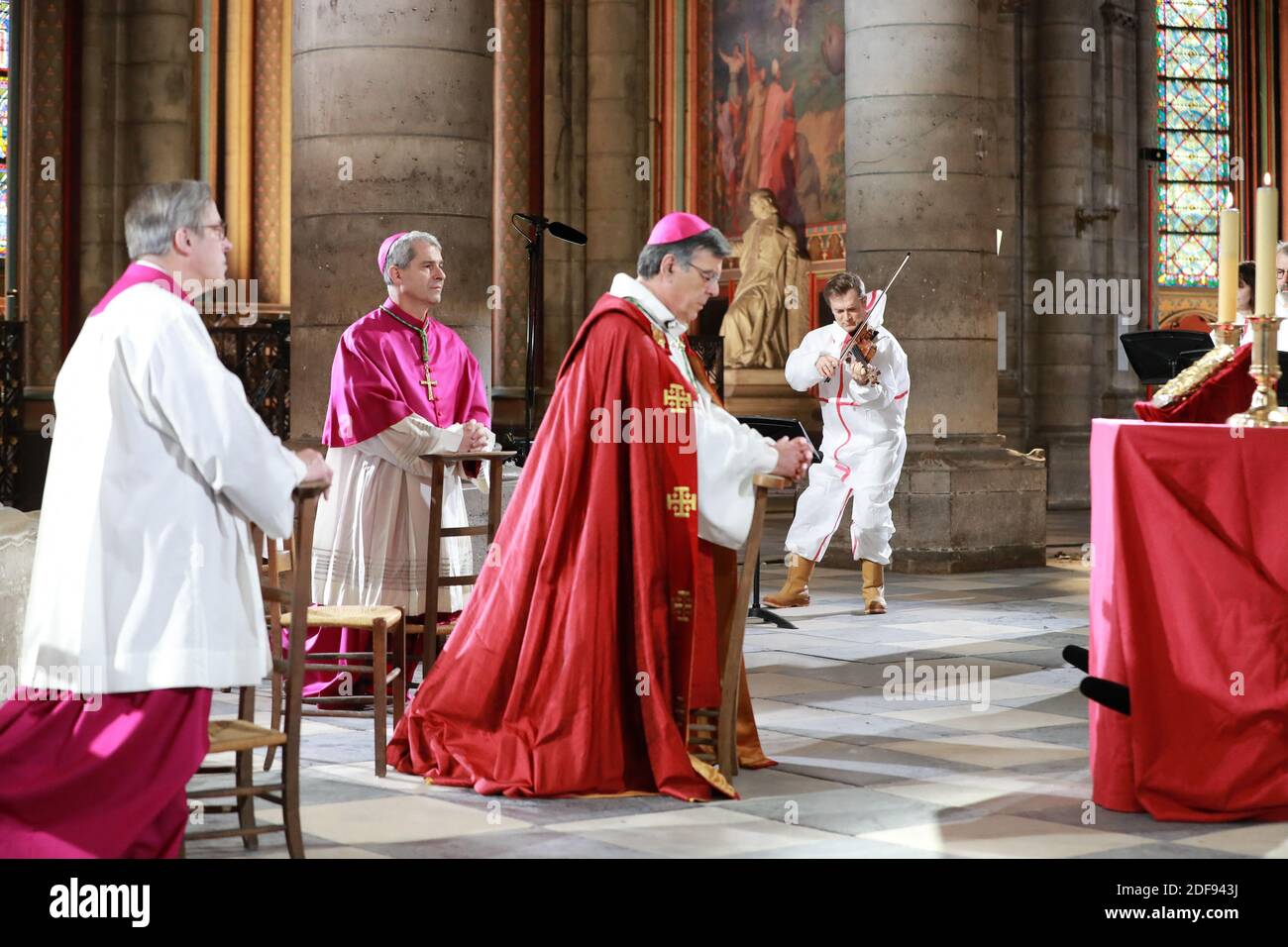 (Da L) il rettore della cattedrale di Notre-Dame de Paris, Patrick Chauvet, Vescovo Ausiliare di Parigi, Denis Jachiet e Arcivescovo di Parigi, Michel Aupetit, partecipano ad una cerimonia di meditazione per celebrare il Venerdì Santo, mentre il violonista Renaud Capucon suona in una parte sicura della cattedrale di Notre-Dame de Paris, il 10 aprile 2020, A Parigi il 25° giorno di un rigido blocco volto a frenare la diffusione della pandemia COVID-19, causata dal novo coronavirus. - Notre-Dame, parte di un sito patrimonio dell'umanità dell'UNESCO sulle rive del fiume Senna, è stato devastato dalla Blaze aprile 15 -- perdendo la sua guglia gotica, il tetto e molti preci Foto Stock