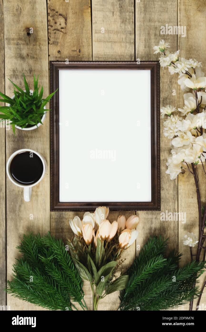 Cornice in legno e caffè con decorazione floreale su sfondo di legno. Rustico nostalgia piatto posato. Foto Stock