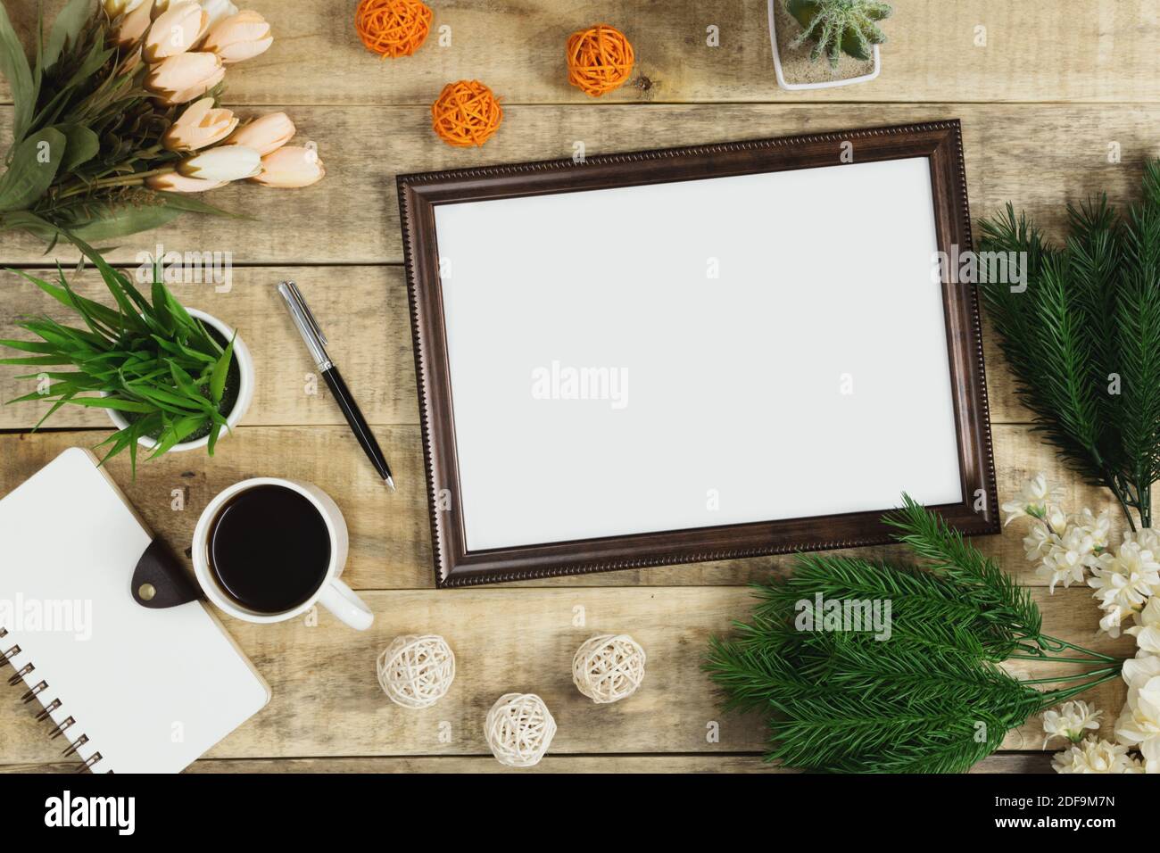 Cornice in legno, diario e caffè con decorazione floreale su sfondo di legno. Rustico nostalgia piatto posato. Foto Stock