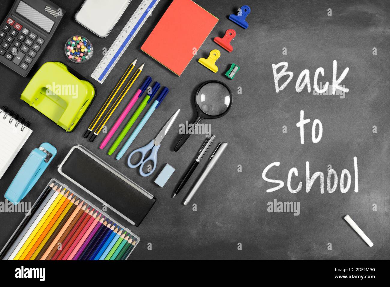 Back to School scritto su lavagna con più articoli di cancelleria. Foto Stock
