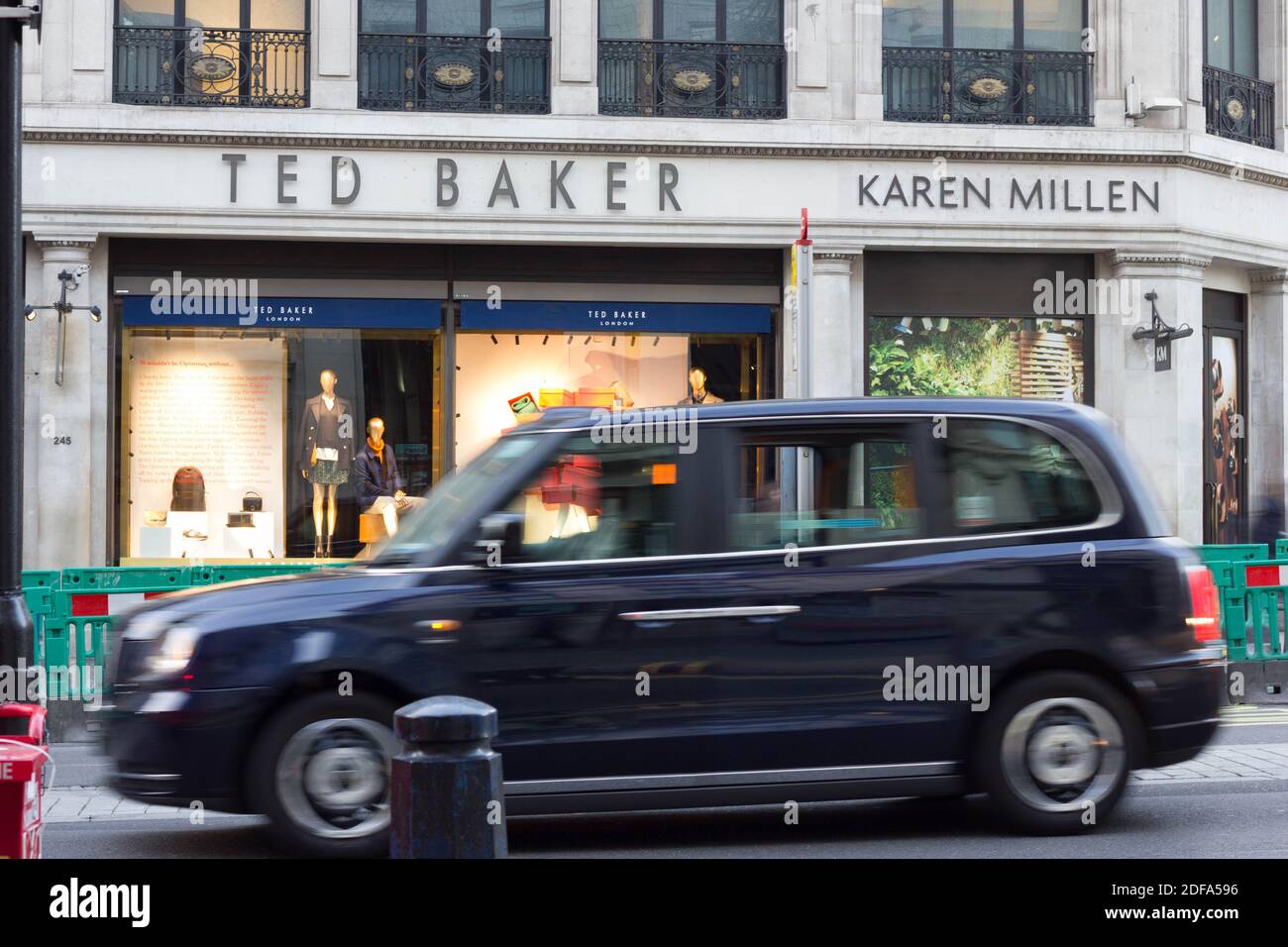 Taxi in taxi nero di Londra, passando accanto ai negozi TED BAKER e KAREN MILLEN su Regent Street, Londra, Inghilterra Foto Stock