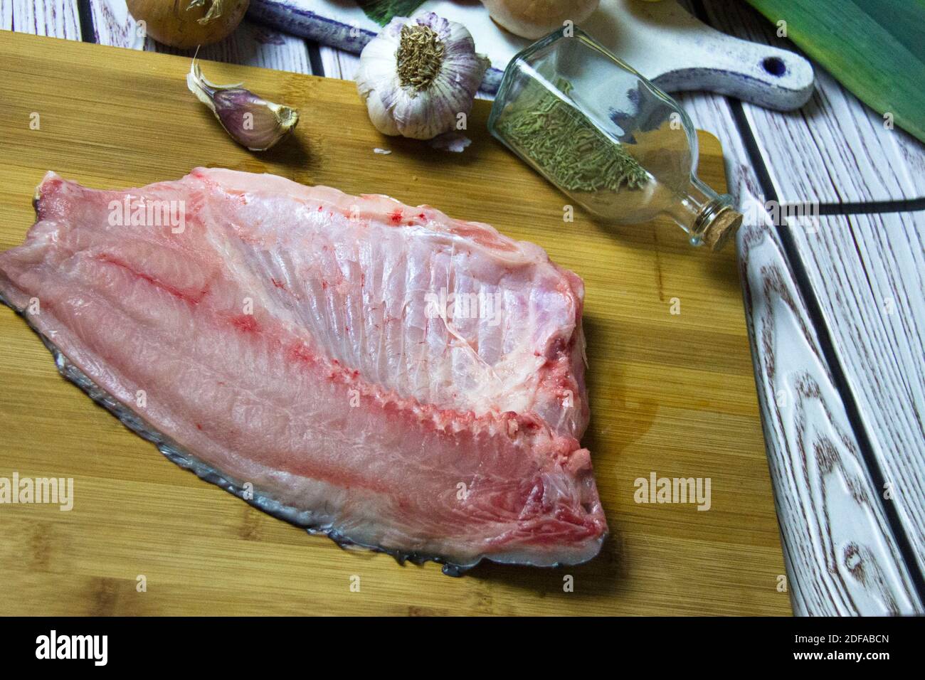 Filetto di pesce fresco crudo di carpa su un tagliere. Cottura sfondo. Foto Stock