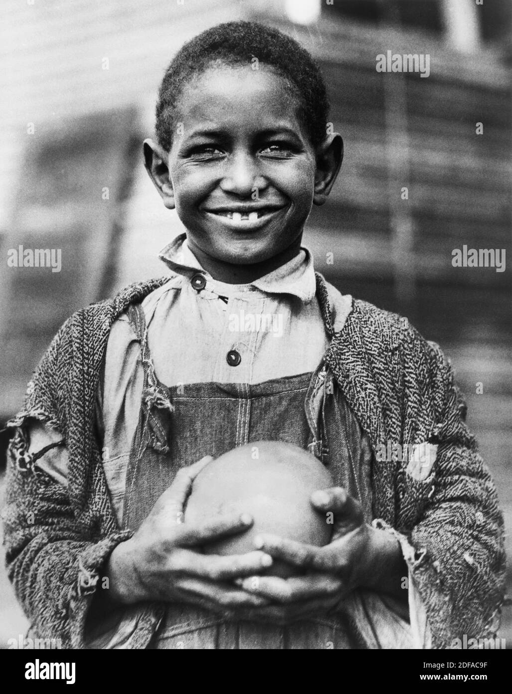 Giovane ragazzo con pompelmo fornito dalla Croce Rossa americana alle vittime della siccità, Mound Bayou, Mississippi, USA, Lewis Wickes Hine, American National Red Cross Collection, 1930 Foto Stock