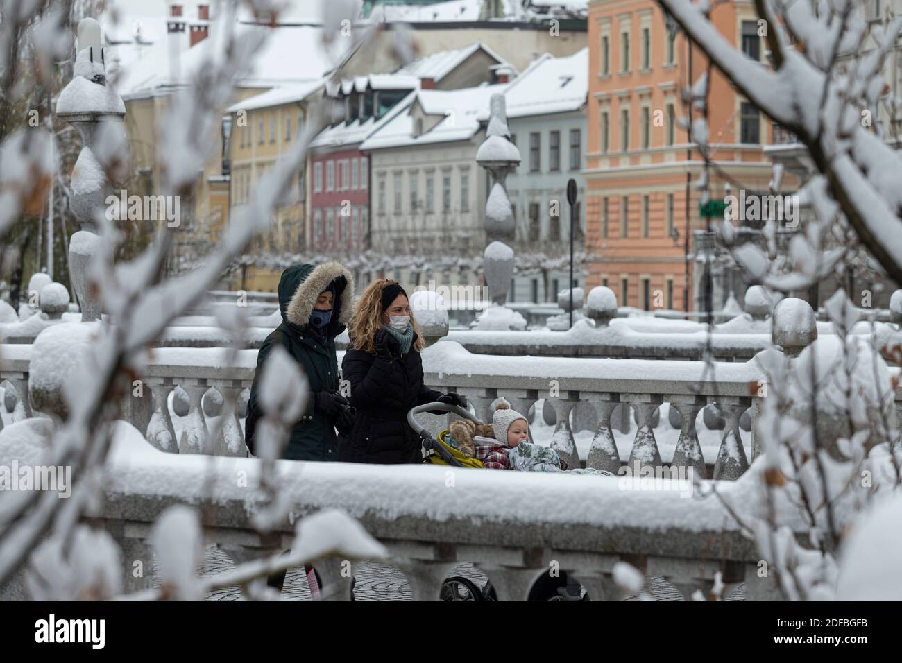 Lubiana, Slovenia. 3 dicembre 2020. Le donne che indossano maschere facciali camminano sul ponte triplo con una carrozza per bambini a Lubiana, Slovenia, 3 dicembre 2020. Giovedì la Slovenia ha segnalato 1,772 nuovi casi COVID-19 nelle ultime 24 ore, portando il bilancio nazionale dei casi confermati a 81,338, secondo i dati ufficiali. Credit: Zeljko Stevanic/Xinhua/Alamy Live News Foto Stock