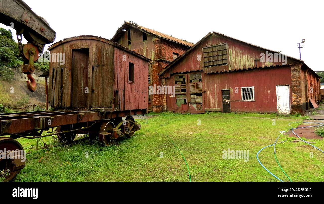 Vecchio carro marcio e arrugginito abbandonato in piedi accanto ad un abbandonato capannone Foto Stock