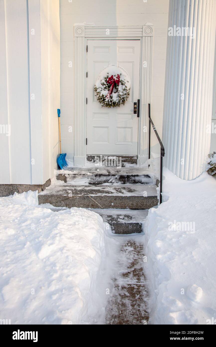 Le corone di Natale ricoperte di neve pendono alle porte della chiesa congrgazionale di Phillipston, Massachusetts Foto Stock