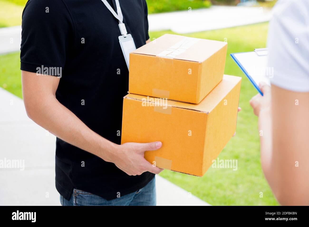 Addetto alla consegna consegna dei pacchi al destinatario - concetto di corriere Foto Stock
