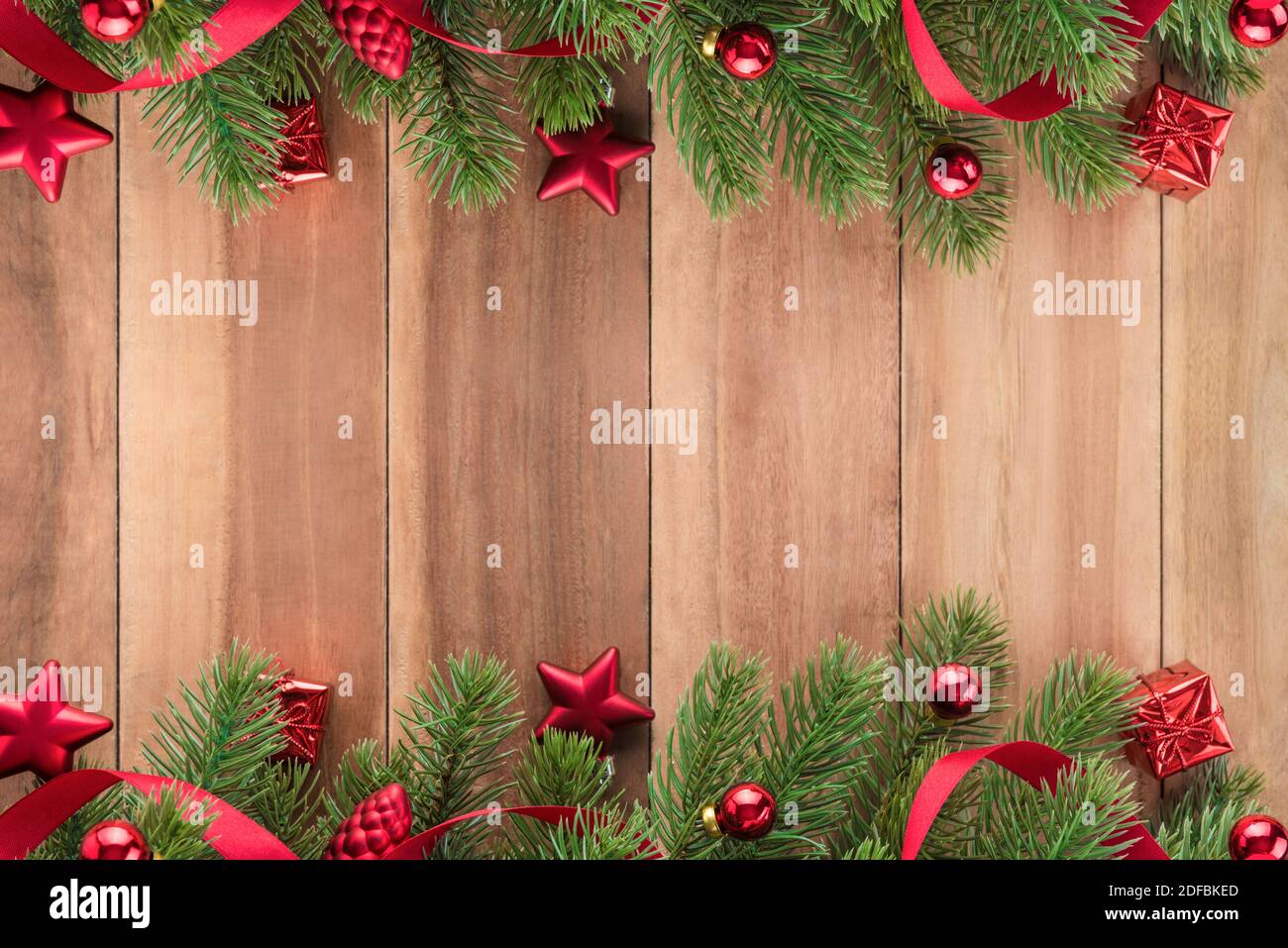 Albero di natale foglie con ornamenti di colore rosso su sfondo legno, design di confine Foto Stock