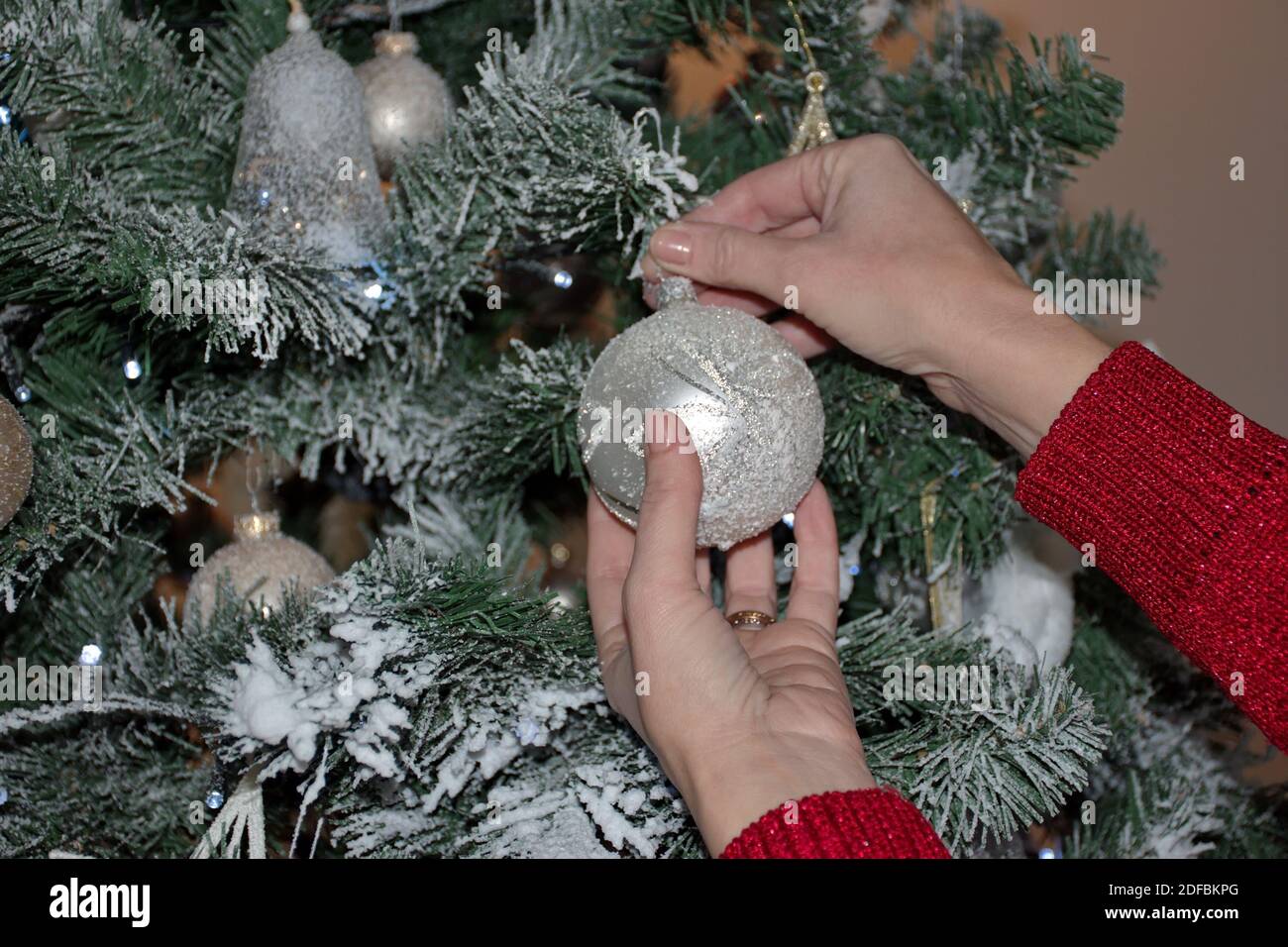 Mani di donna in maglione decorazione albero di Natale Foto Stock