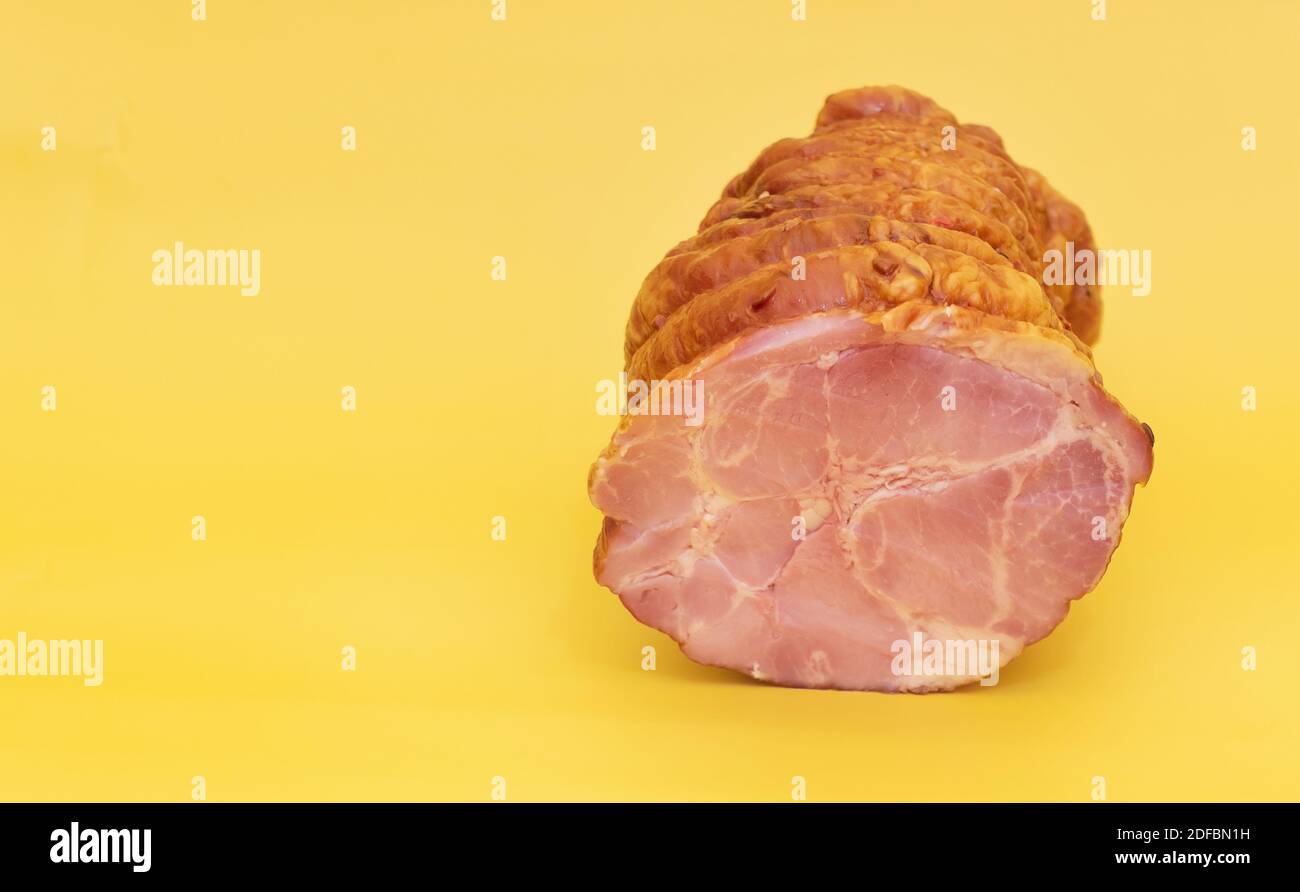 Un pezzo di Salame su sfondo giallo. Foto Stock