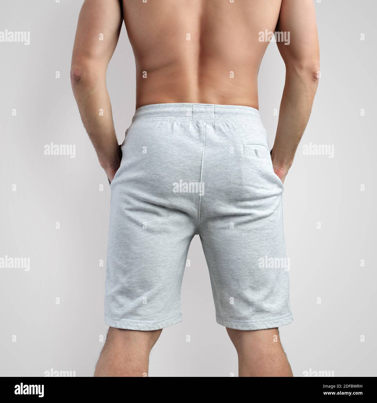 Modello di shorts bianchi maschio per la presentazione del design, vista posteriore. Modello di vestiti bianchi su uno sfondo isolato per la pubblicità nel stor online Foto Stock