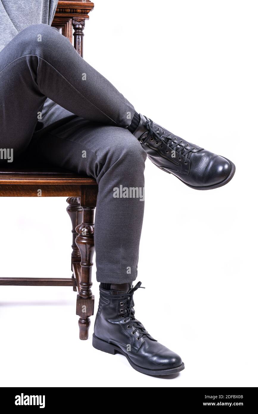 Uomo seduto sulla sedia, gambe da vicino isolato su sfondo bianco Foto Stock