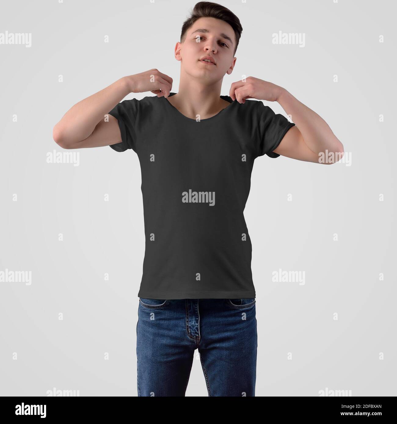 Mockup di una T-shirt nera su un ragazzo giovane, vista frontale, isolato su uno sfondo bianco. Modello per la presentazione del design e per la pubblicità nella o Foto Stock