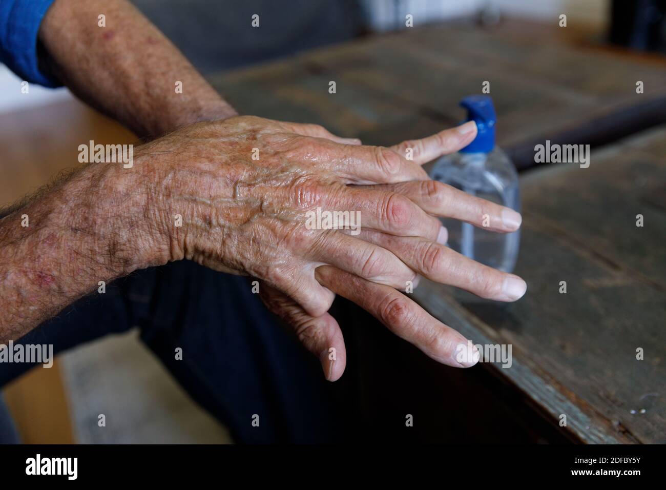 Vista ravvicinata di un uomo caucasico anziano che utilizza un disinfettante per le mani a casa Foto Stock