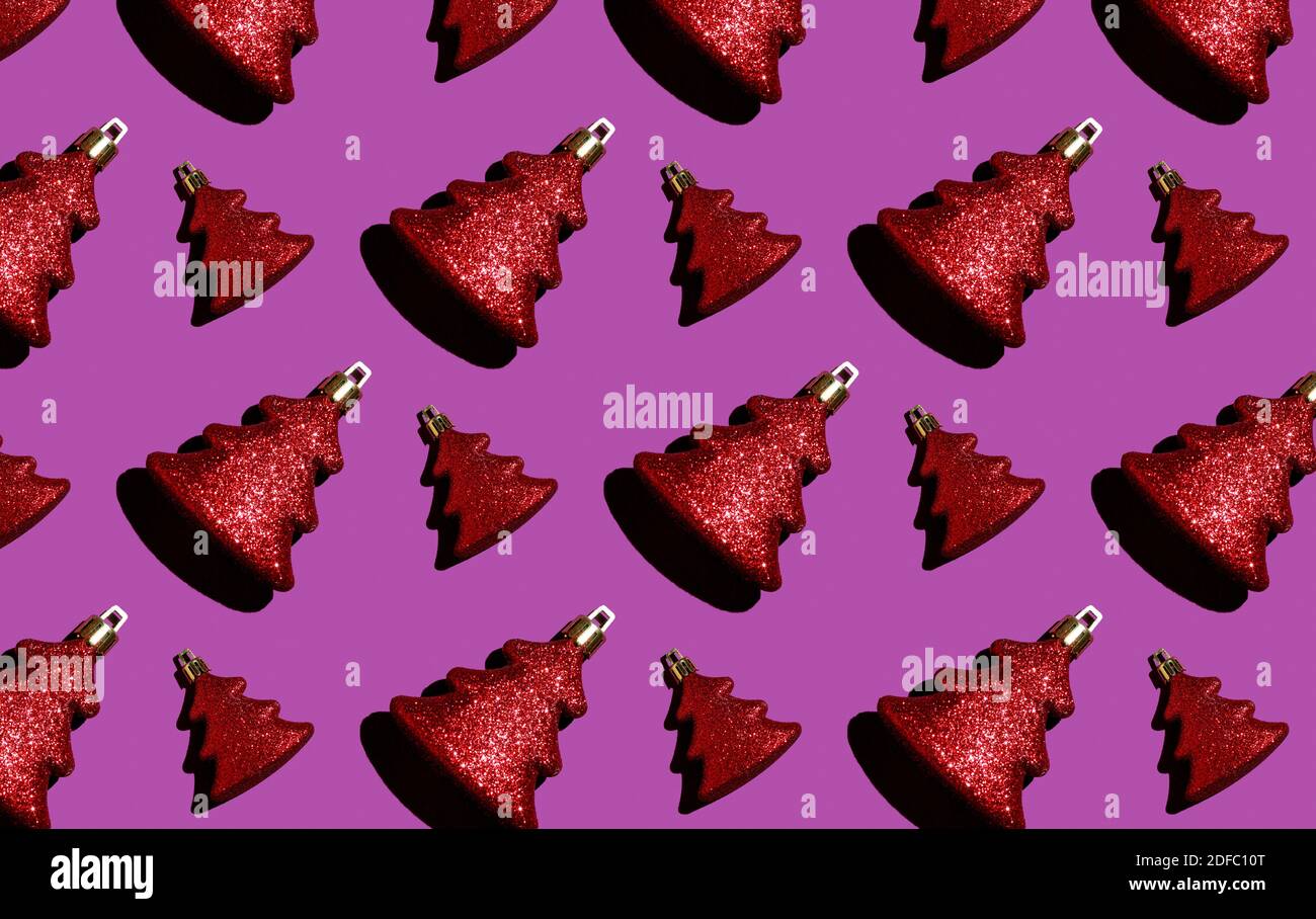 Modello natalizio senza cuciture. Giocattolo rosso di Natale su sfondo viola. Avvolgimento. Foto Stock