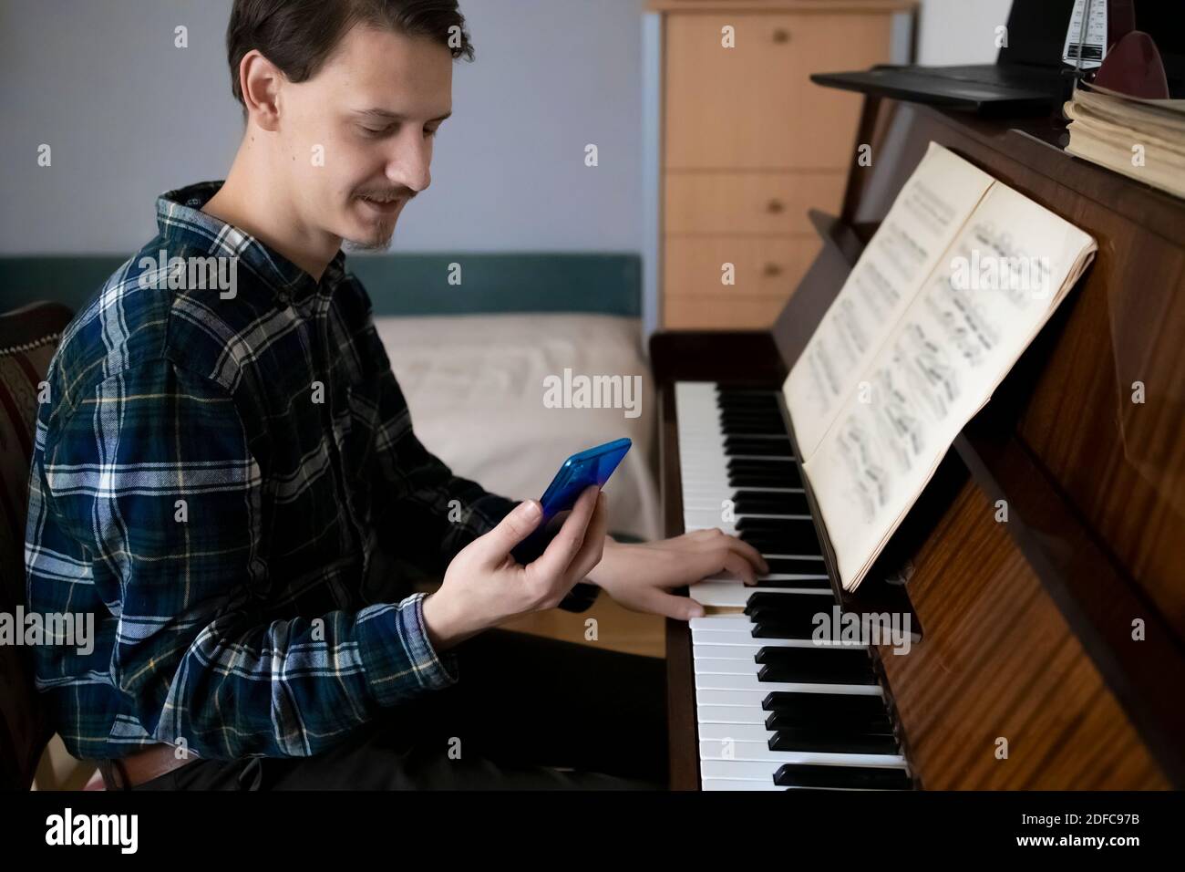 Insegnante che suona il pianoforte durante la sua lezione online Foto Stock