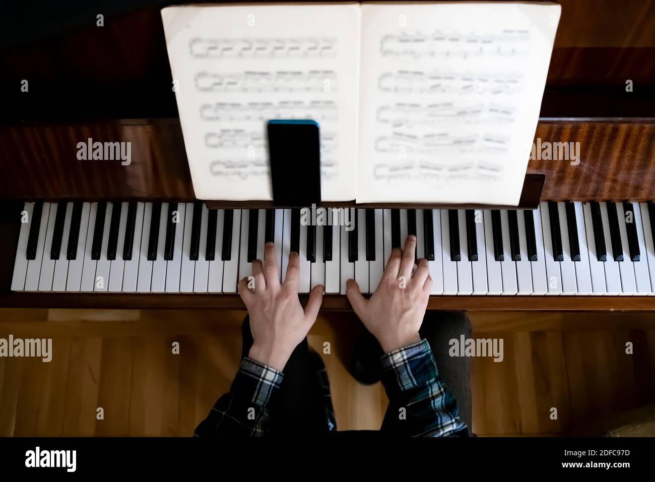 Insegnante che suona il pianoforte durante la sua lezione online Foto Stock