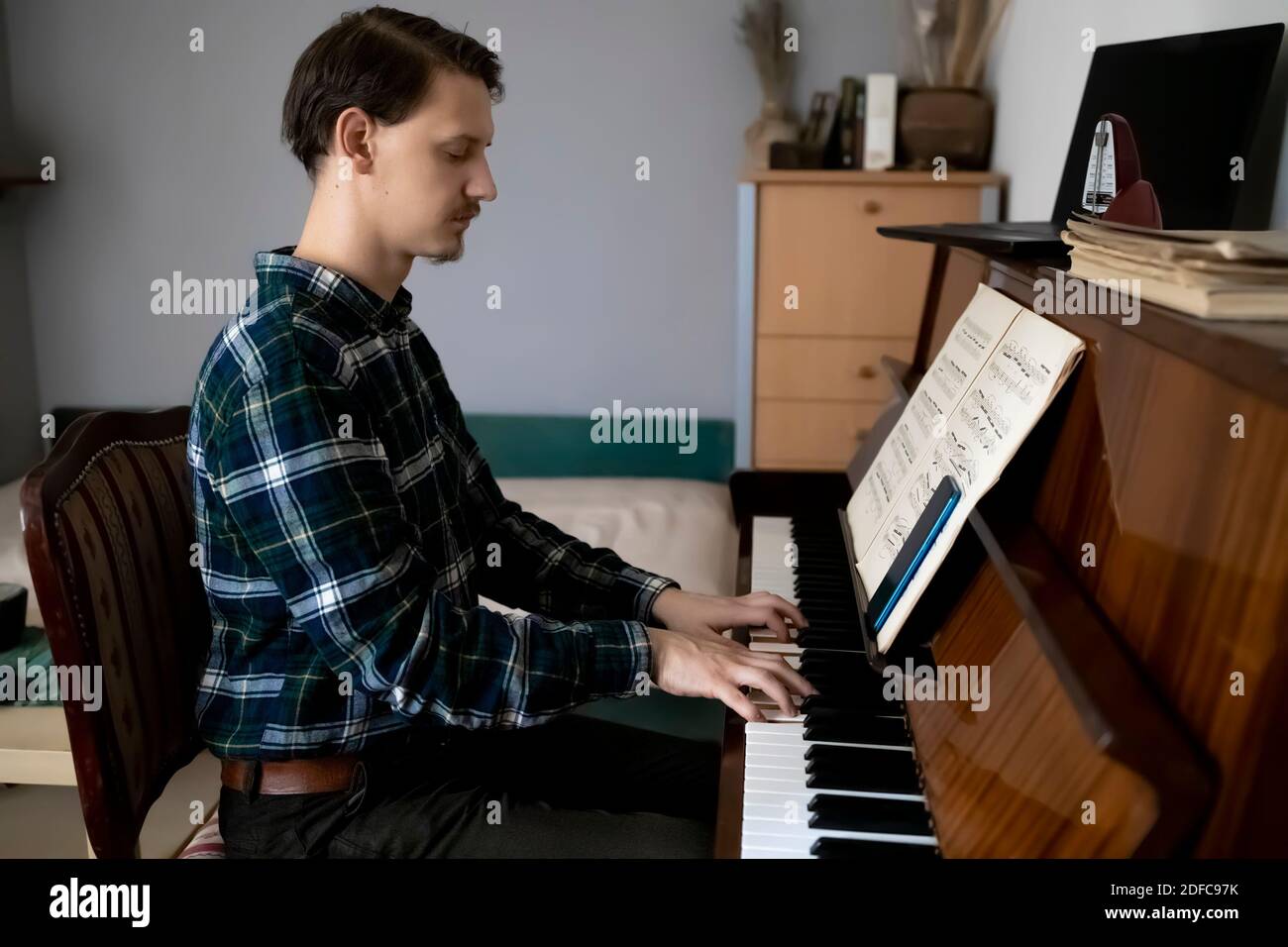 Insegnante che suona il pianoforte durante la sua lezione online Foto Stock