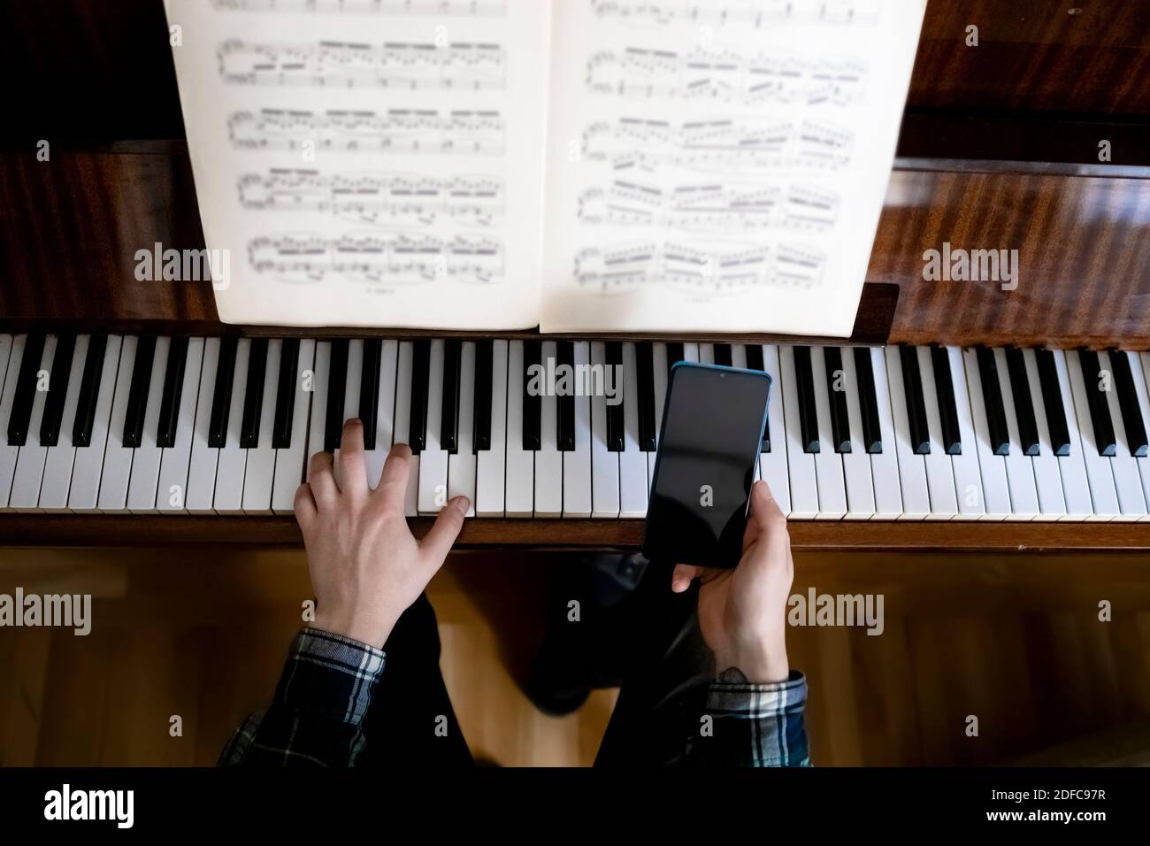 Insegnante che suona il pianoforte durante la sua lezione online Foto Stock