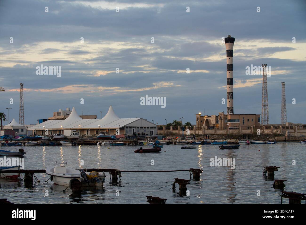 Tripoli, Libia - 25 novembre 2020: Il porto di Tripoli durante il tramonto in una normale giornata lavorativa. Foto Stock