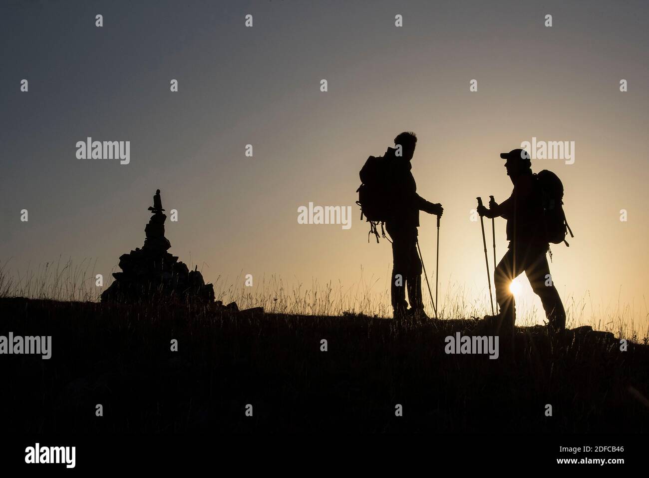 Francia, Alpi alte, Gap, escursioni alla montagna di Charance all'alba, due escursionisti all'alba alla croce di Cote Plaine Foto Stock